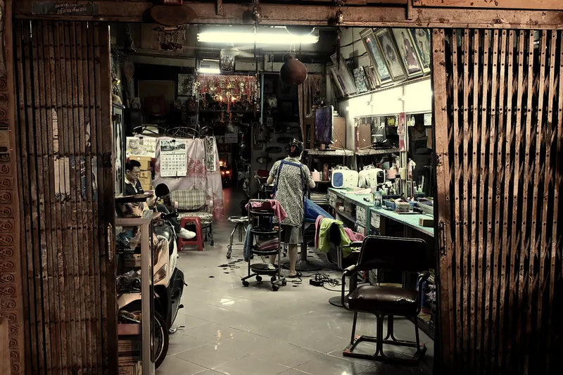 Barbería de barrio abierta de noche, con luz de tubo (foto ilustrativa)
